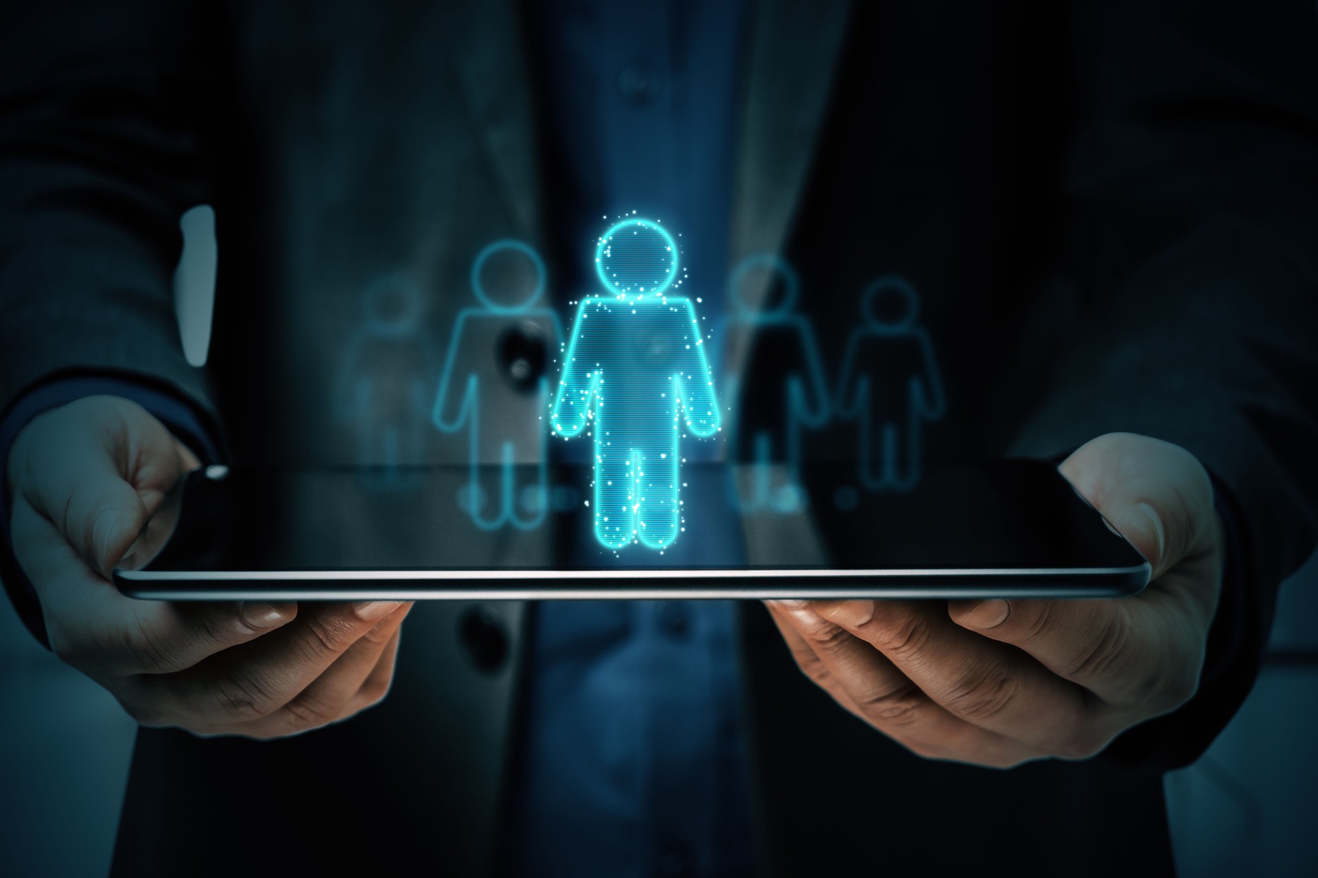 Businessman holding tablet with neon hologram icon of man.